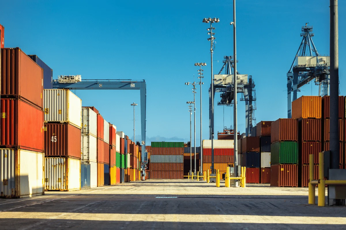 Stacked cargo containers in various colors at a shipping dock.