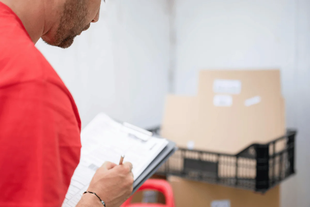 The Only Freight Documents Guide You’ll Need 14 Logistic staff member documenting inventory on a clipboard.