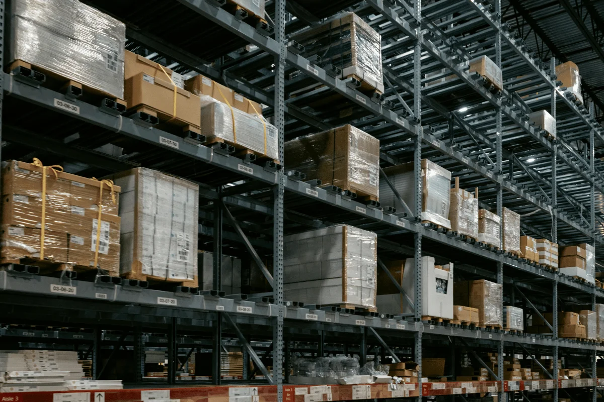 Logistics storage facility with tall metal racks filled with boxed inventory.