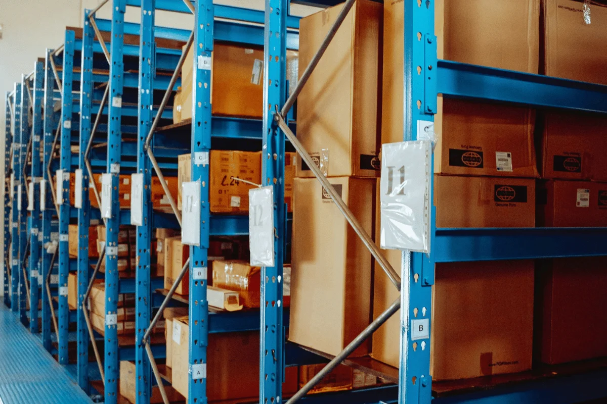 Warehouse shelves filled with boxes, labeled with numbers and organized for storage.