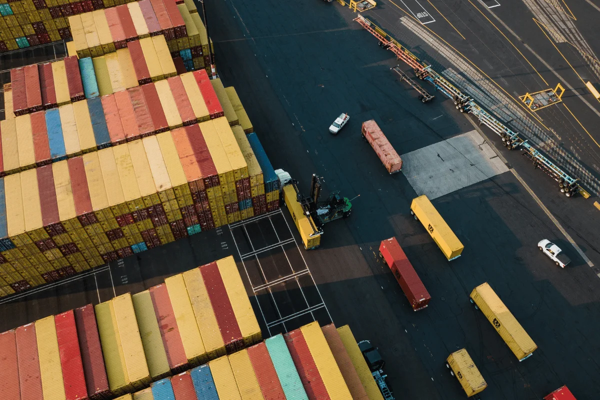 Shipping from Thailand to the USA: Challenges, Solutions & More 12 Aerial view of stacked shipping containers in a busy port yard.