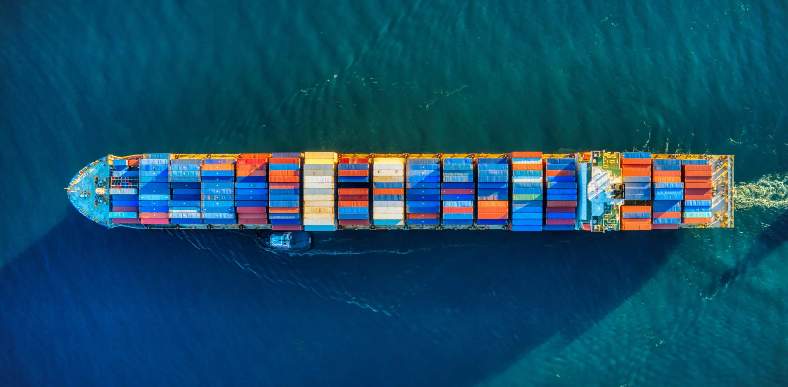 Cargo ship loaded with shipping containers at port terminal, showcasing global trade and digital freight forwarding logistics.
