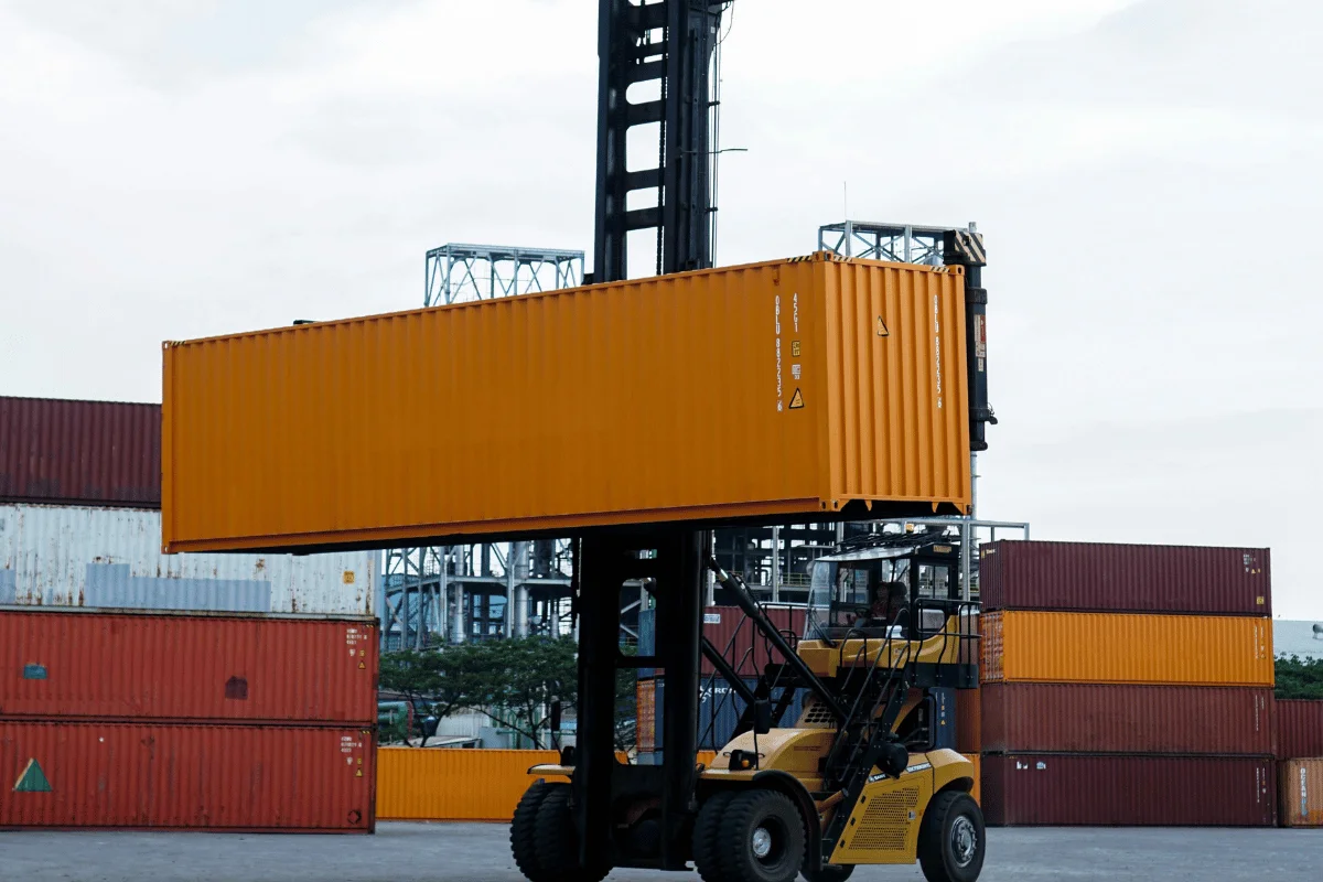 GRI in Shipping: Factors, Impact, and Tactics 13 Cargo container being transported by an industrial forklift.