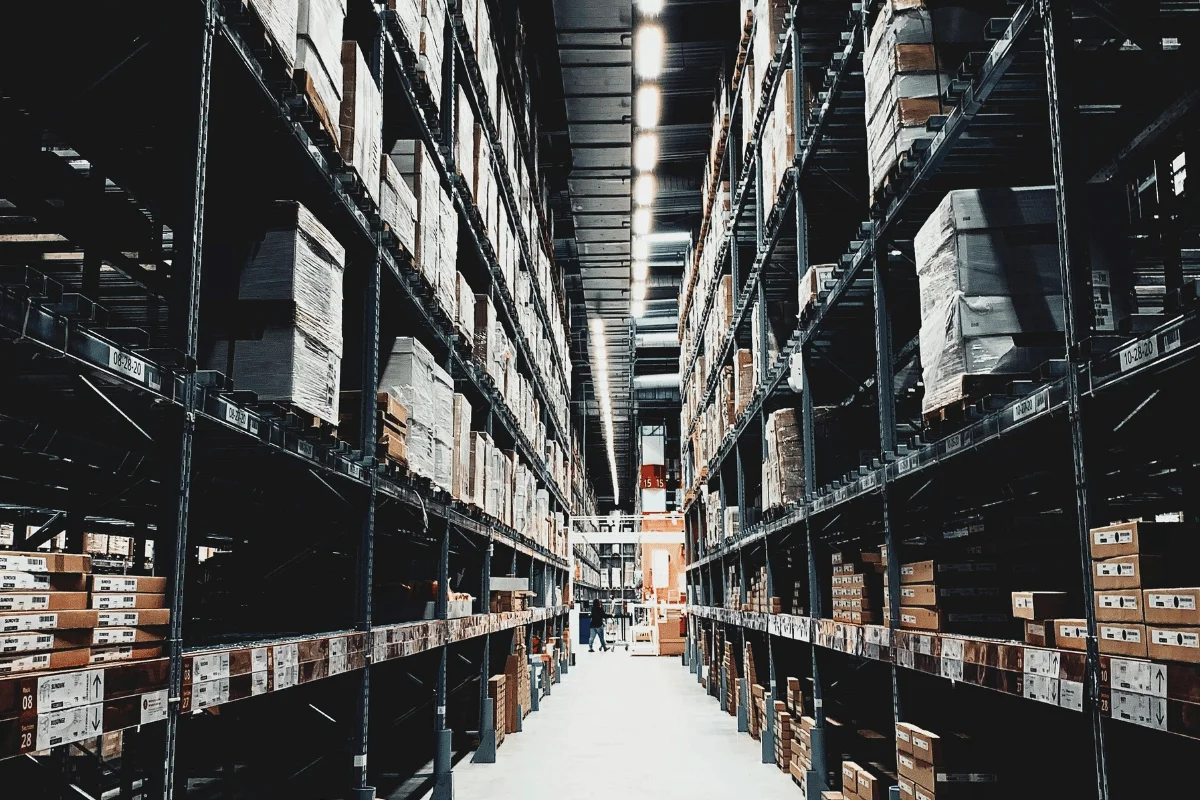 Large industrial warehouse with tall racks stocked with inventory and supplies.