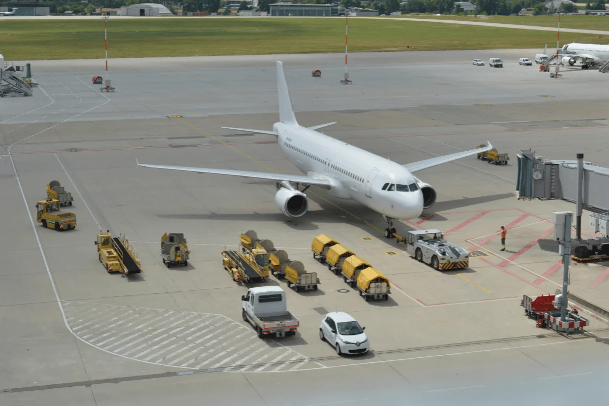 Commercial airplane parked at an airport terminal with ground support vehicles.