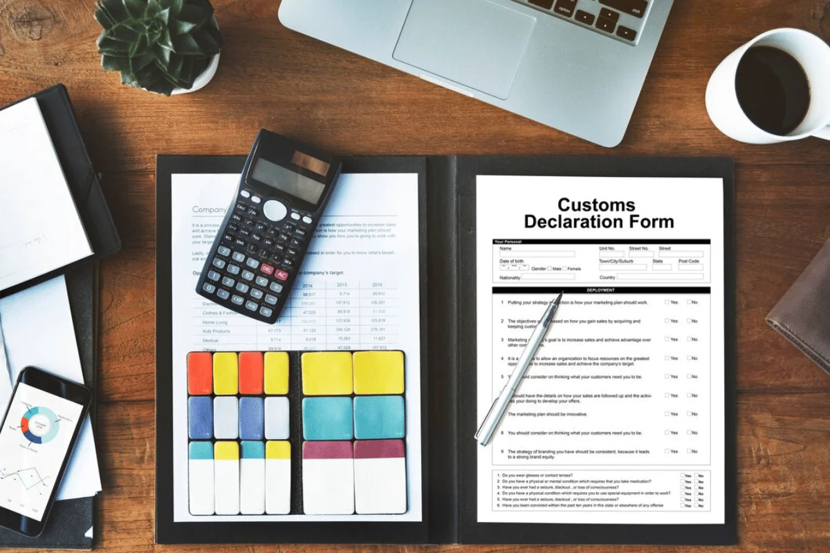 Customs declaration form on a desk with calculator and sticky notes.
