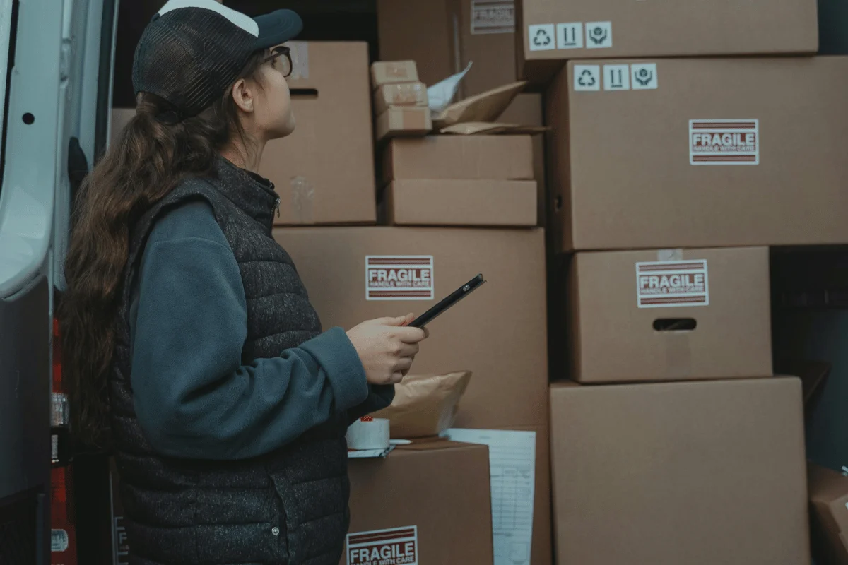 Warehouse worker inspecting labeled boxes marked as fragile.