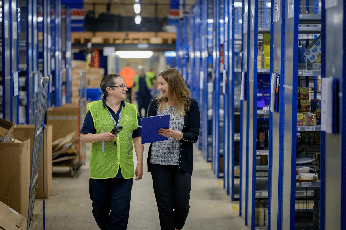 Freight Forwarders in Texas: Significance, Challenges & Tips 7 Warehouse staff reviewing items and talking during a walk-through.
