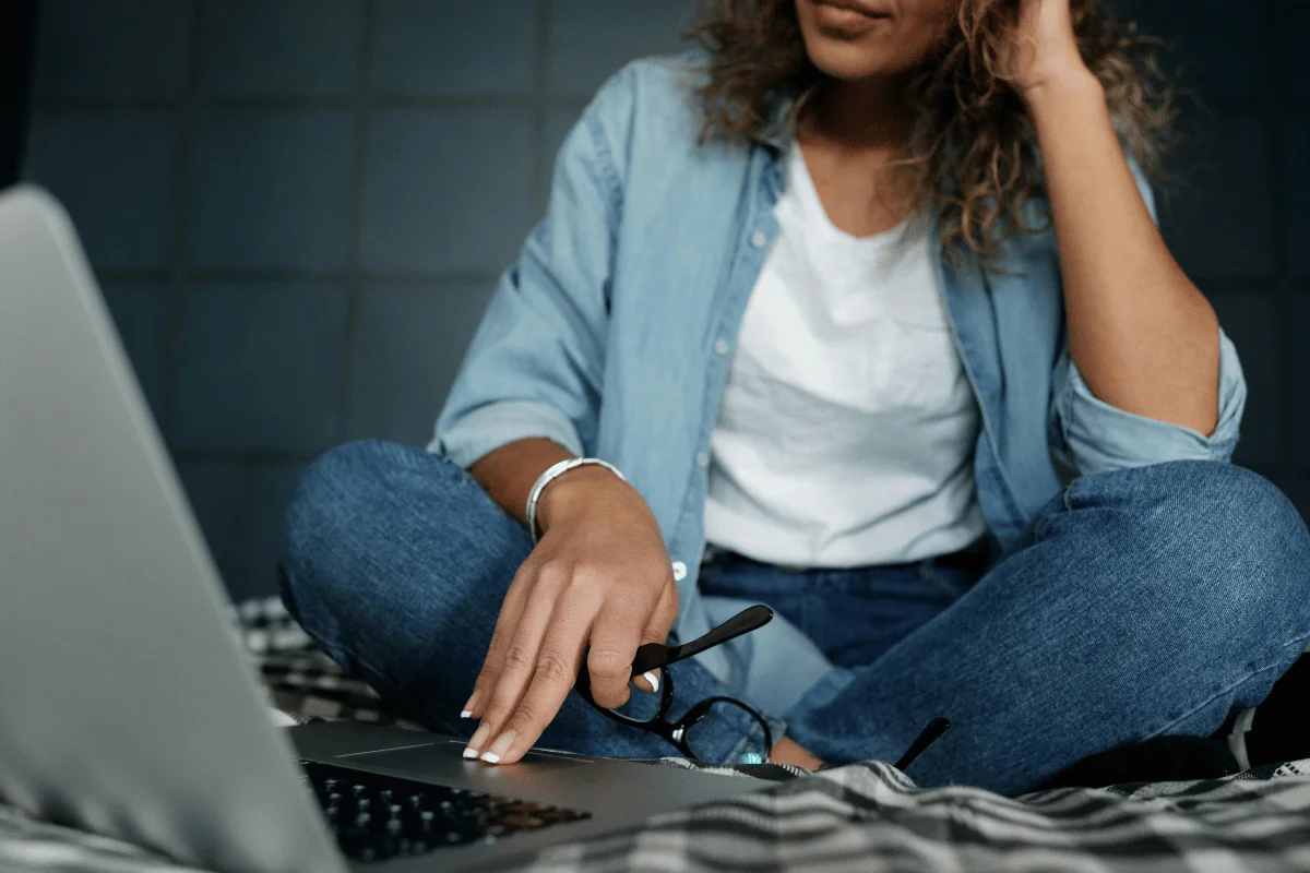 Casual working moment: woman in denim browsing on a laptop.