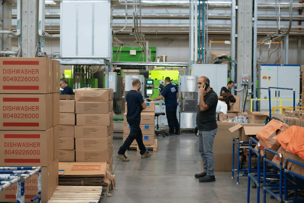 How to Choose the Best Freight Forwarder From China to USA 14 A man on a phone call in a busy warehouse.