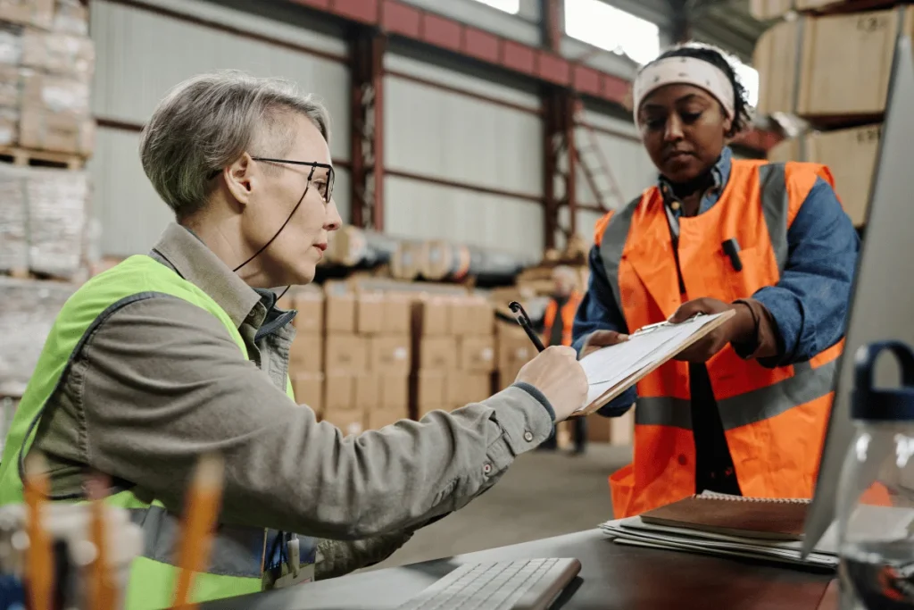 Can I Import Without a Freight Forwarder? When It Works and When It Fails 6 Two warehouse workers in safety vests in a warehouse.