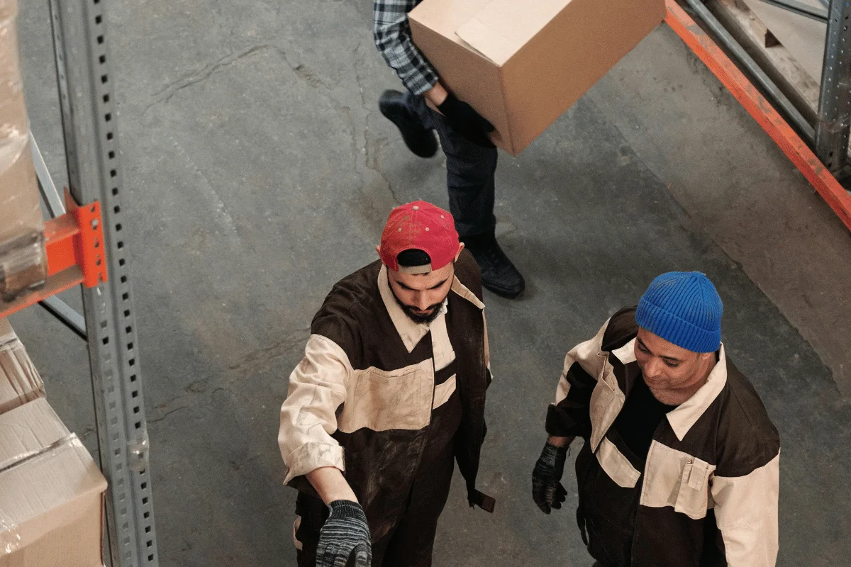 Warehouse workers organizing and handling packages in a fulfillment center.