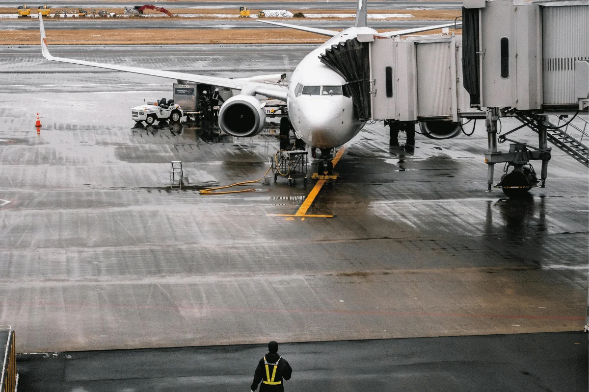 Boeing jet parked at the terminal with ground crew working.