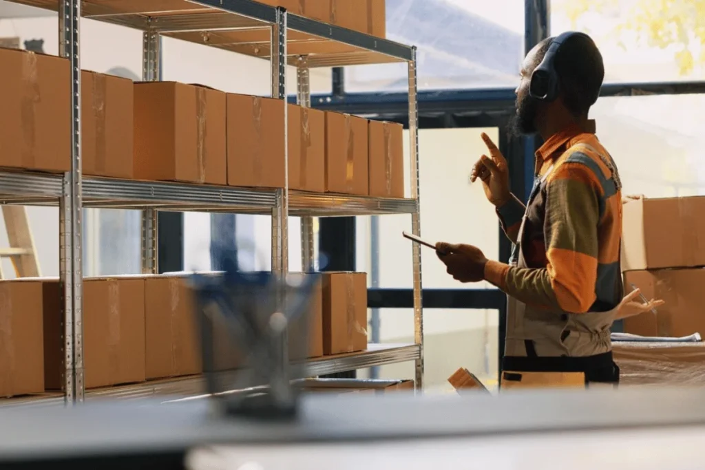 A worker with headphones inspecting warehouse inventory.
