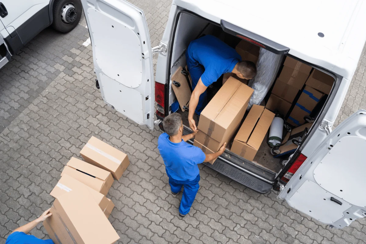 Supplier Scorecard Template: How to Compare Quotes from Multiple Factories 3 Two individuals loading cardboard boxes into a white van.