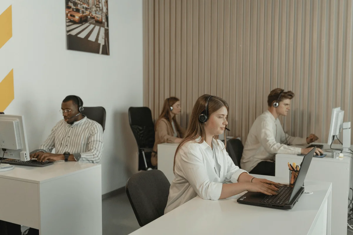 Freight Forwarder vs. Broker: Functions & Use Cases Compared 18 Call center agents working at desks with headsets in a modern office environment.