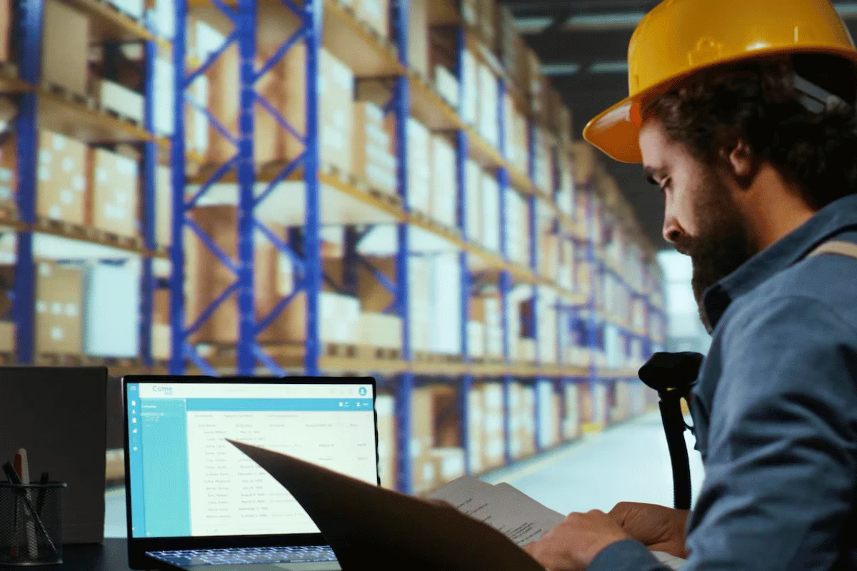What Are Spot Rates in Shipping? 6 Man in yellow helmet using computer for warehouse inventory control.