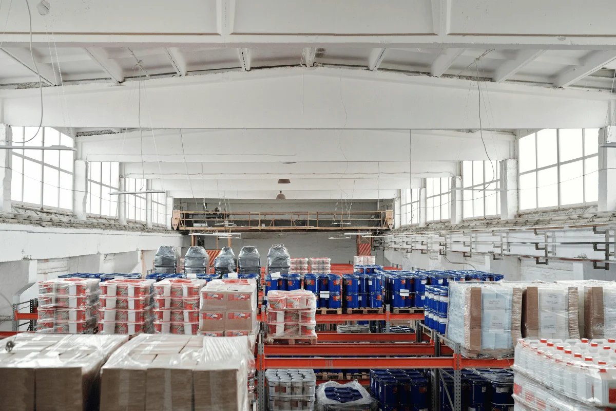 Forklift loading wooden pallets in a warehouse.