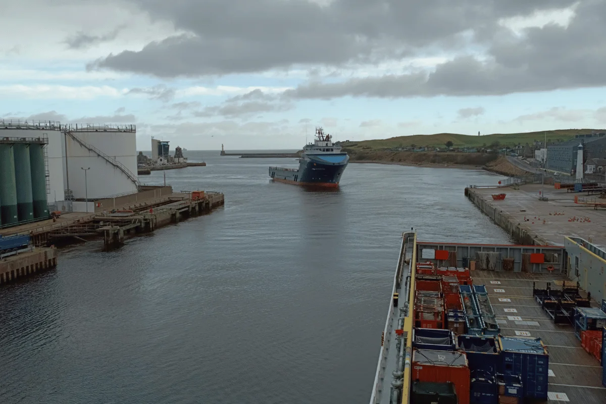 How to import goods from India 6 A cargo ship sails through a calm industrial port.