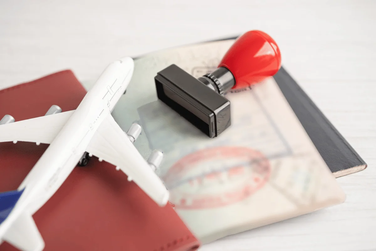Freight Forwarders in Houston, TX: Services & Challenges 9 Model airplane on a passport with visa stamps and a red rubber stamp.