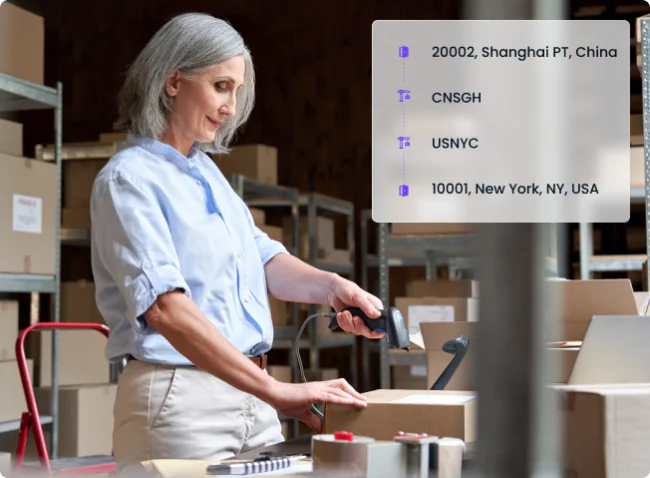 A warehouse worker scanning a package in a storage facility filled with cardboard boxes and shelves. An overlay displays shipping details from Shanghai, China, to New York, USA, representing international shipping, freight forwarding, and logistics tracking.