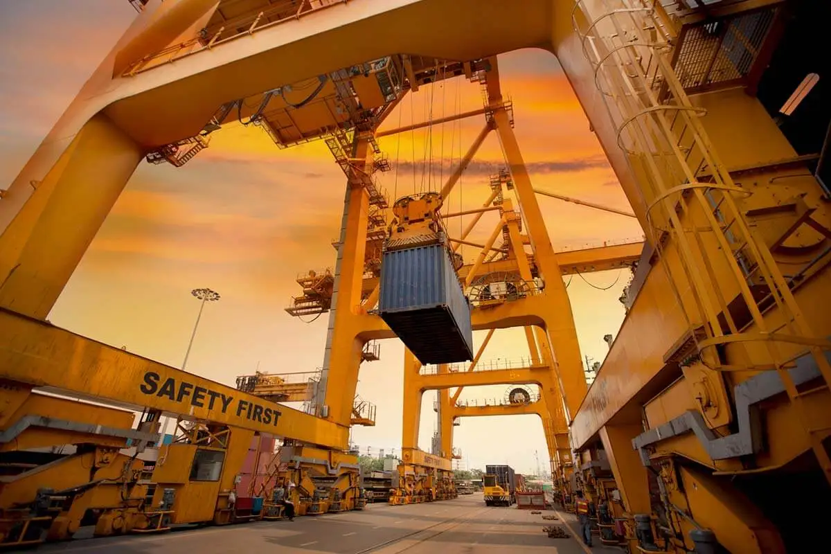 How to calculate landed cost when importing from China to the USA 1 Landed cost in freight shipping - image of a container lifted by a crane