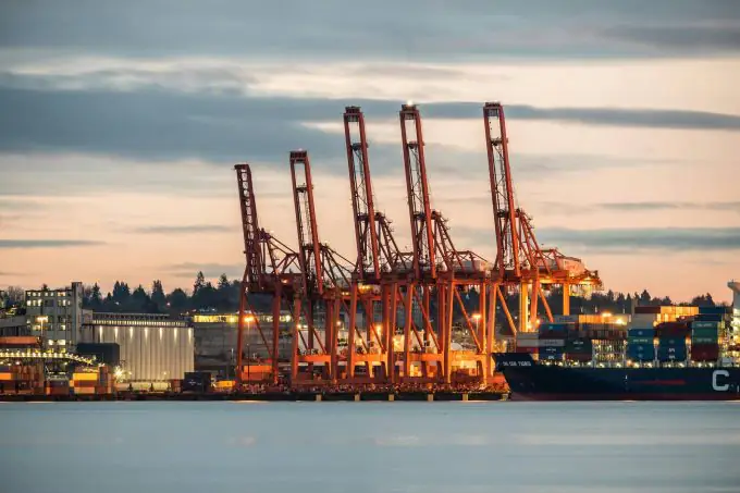 Shipping 11 Sunset view of the port of Vancouver, with large cranes, lighten buildings, and vessels - seen from the sea.