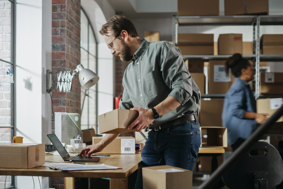 Delivery man in a red uniform handing a package to a customer at the door.