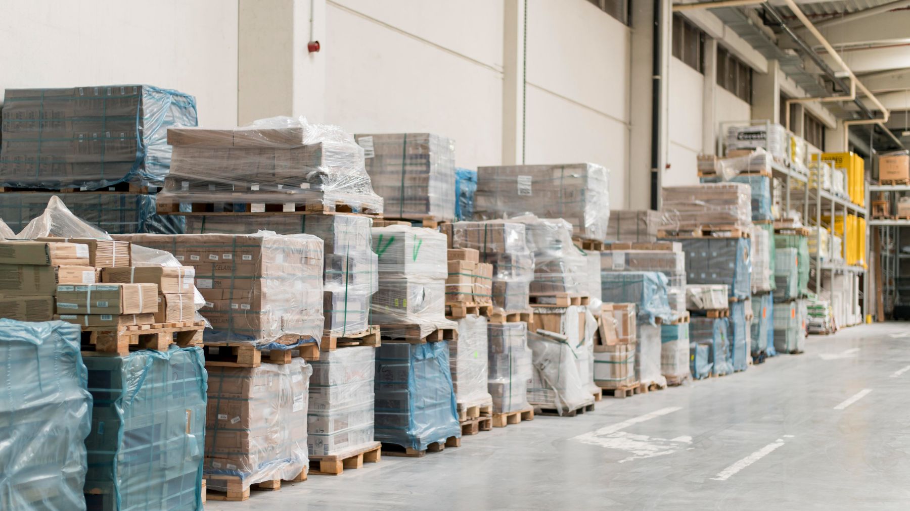 A row of palletized freight stacked one on top of the other at a logistics facility.